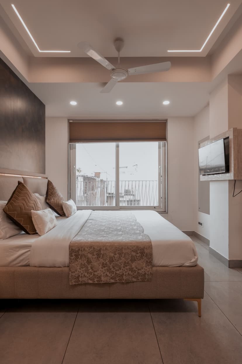 Bedroom with upholstered headboard and city-view window