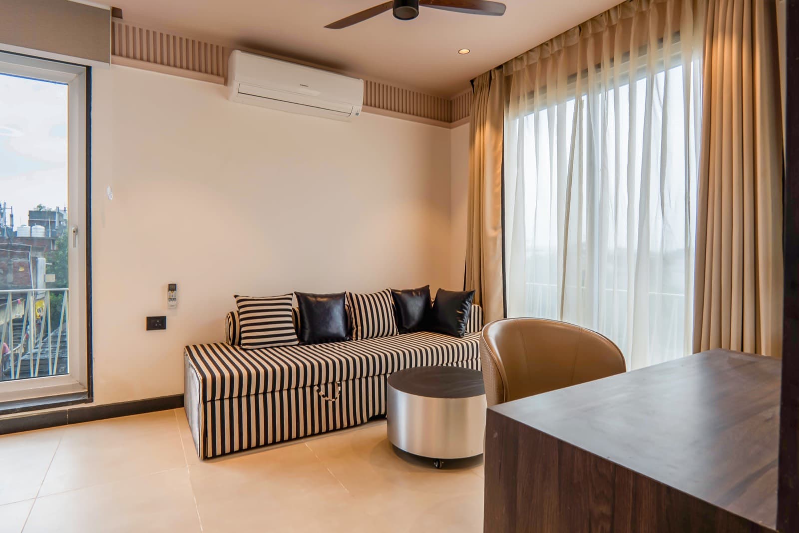 Living area with striped sofa and city-view window